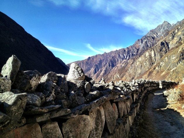 This is called a Mani wall. They are built periodically along the valley by Tibetan Buddhists. The stones are carved with ancient spiritual inscriptions to remember the dead. Some of the Mani walls are over 400 years old.