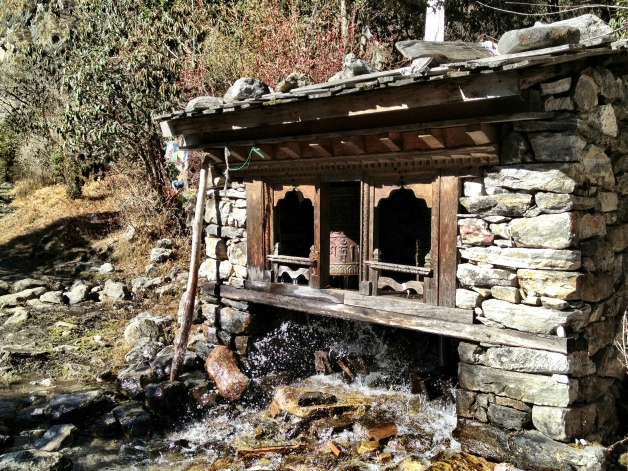 Prayer wheels being turned by the stream water, in the middle of the remote mountains.